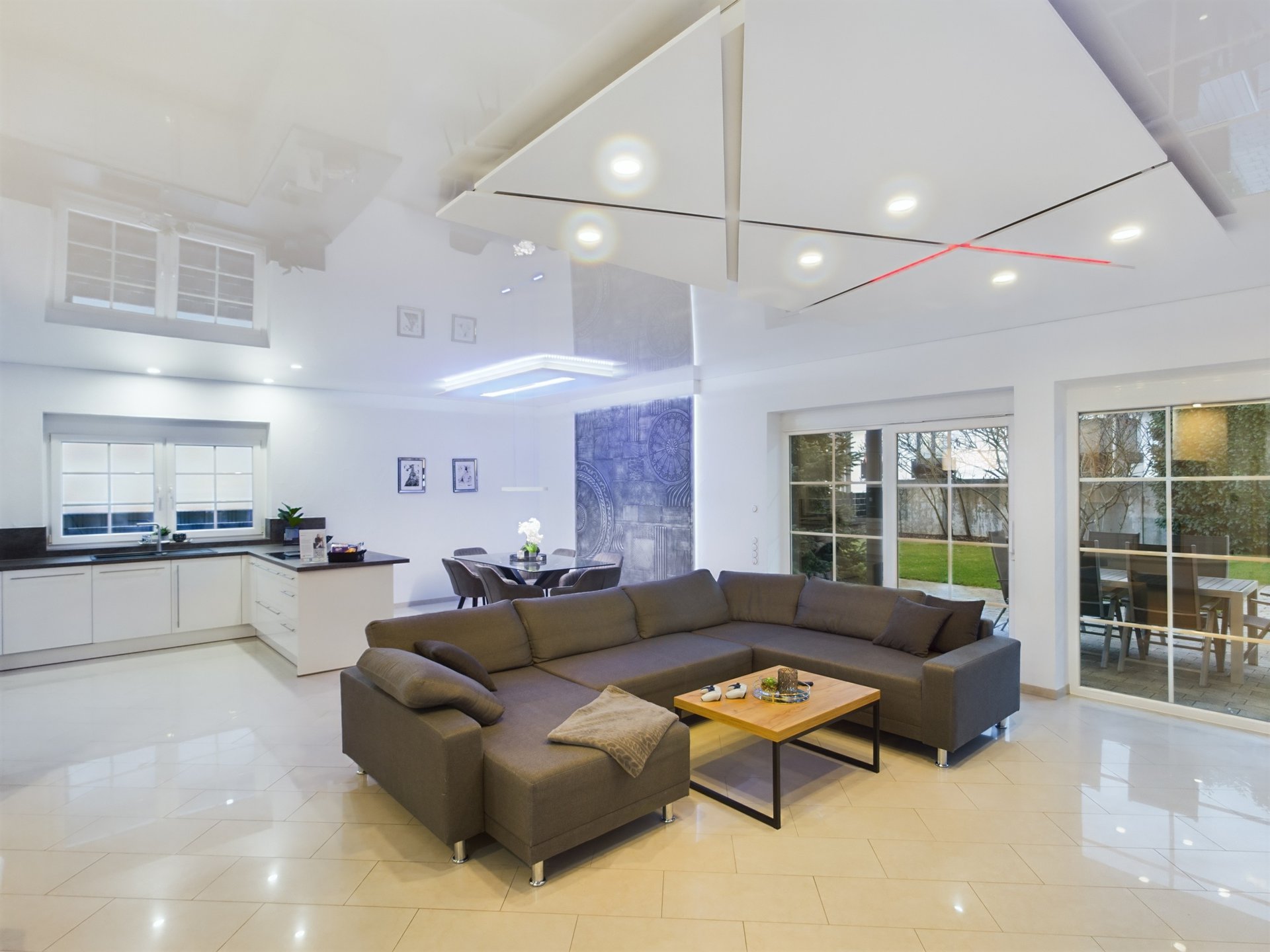 siegelbach-59a-31 Modern living room with large windows and open-plan kitchen in a spacious TLA apartment.