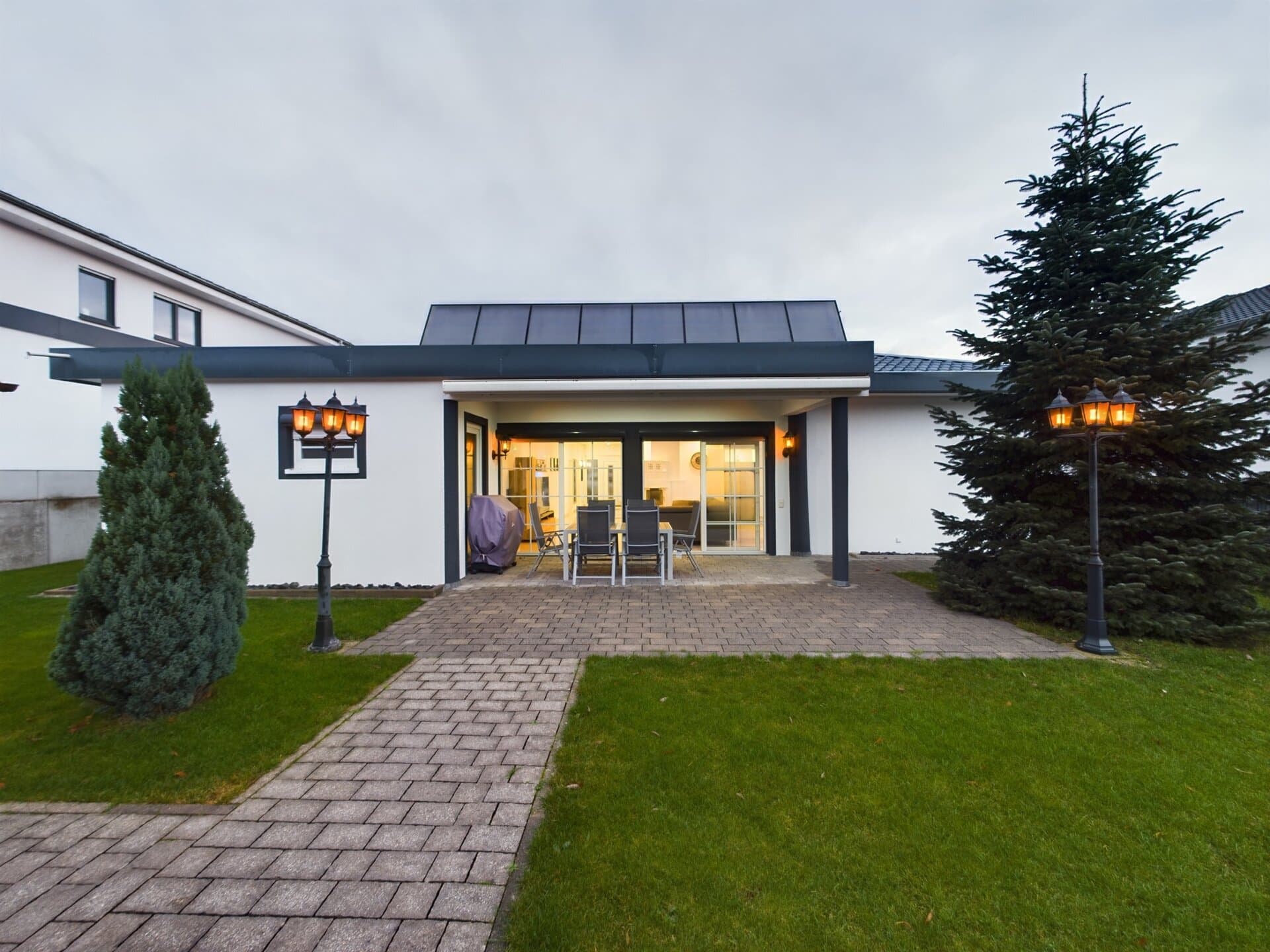 siegelbach-59a-48 Modern single-story house with a white exterior and black roof near Ramstein Air Base.