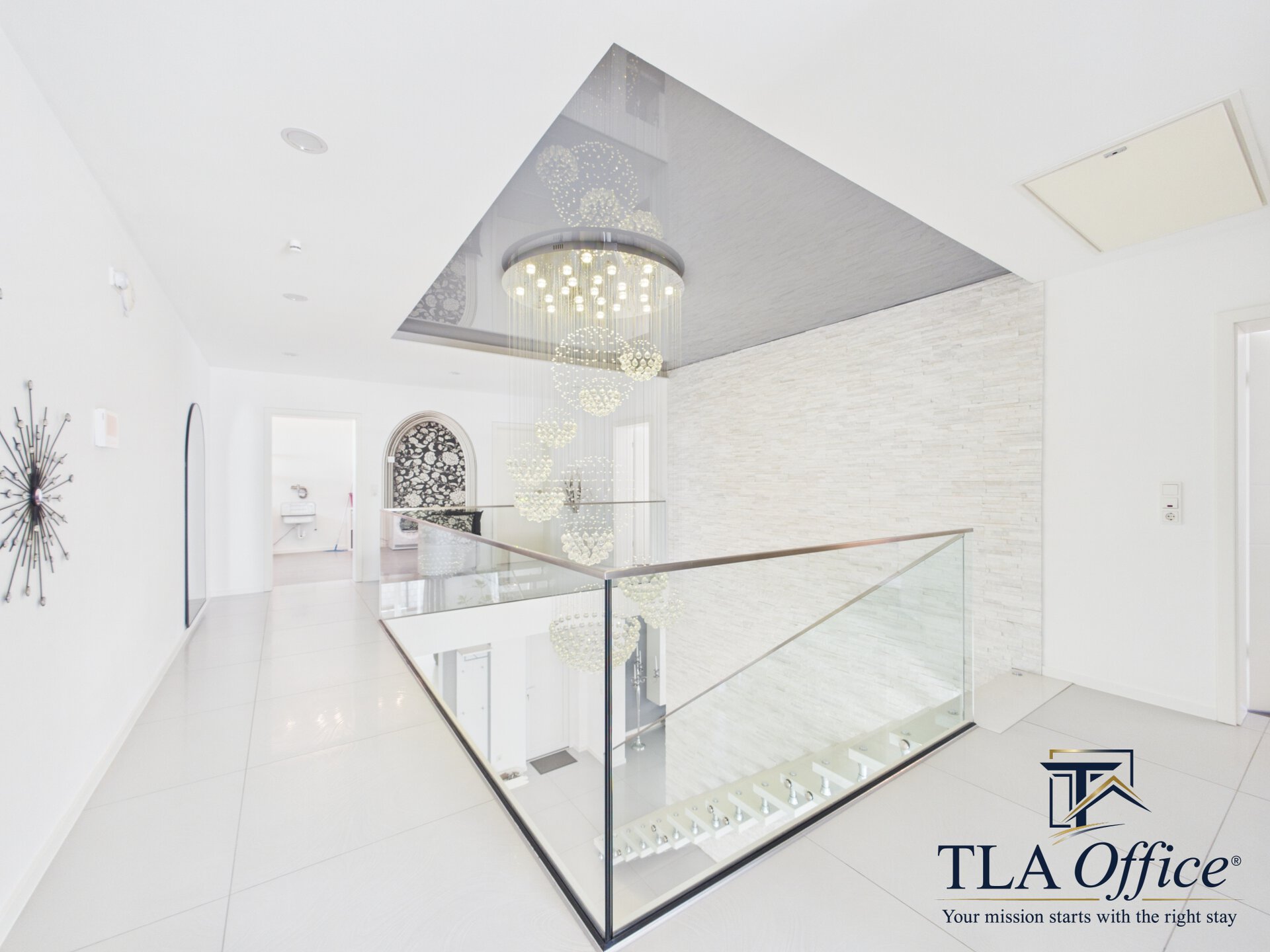 CAM01139G0-PR0080-STILL085 Upper floor landing with glass balustrade and chandelier - Luxury TLA Residence Siegelbach