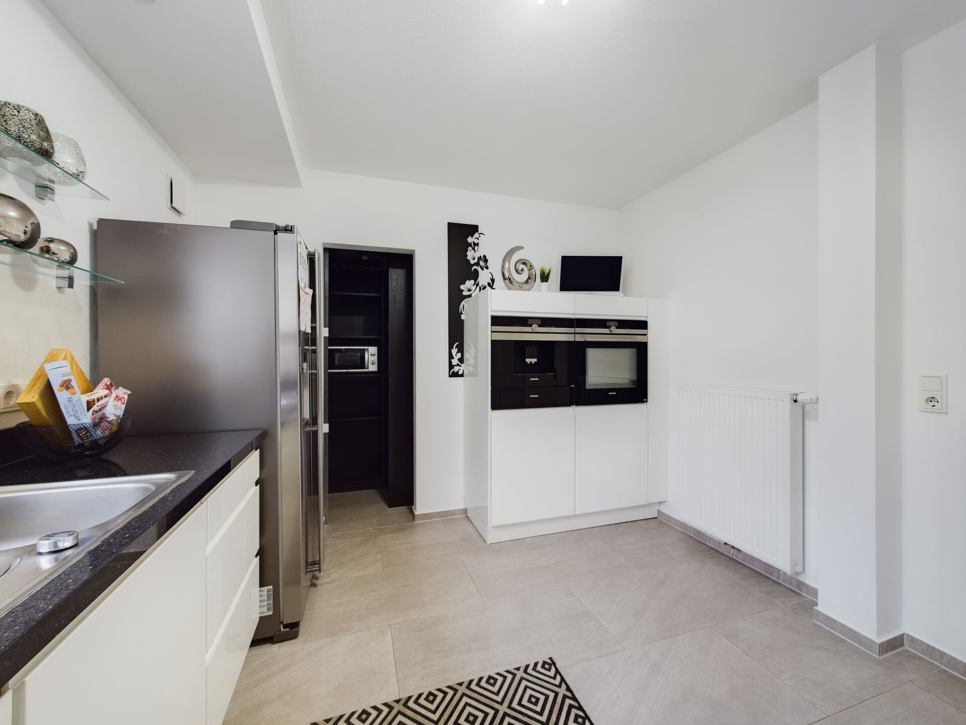 Modern kitchen with stainless steel appliances and white cabinetry in a spacious Kaiserslautern home.