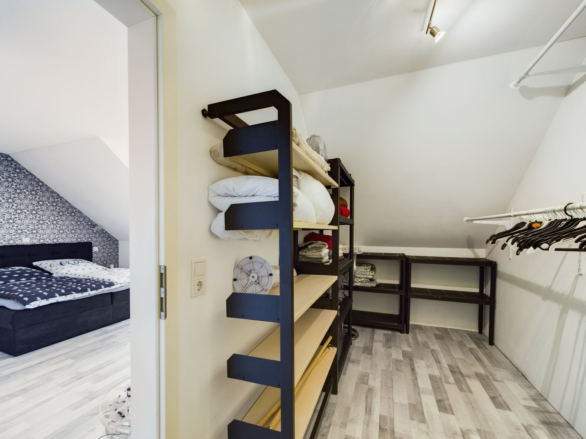 Spacious walk-in closet with shelves and hanging space in a modern TLA house near Ramstein Air Base.