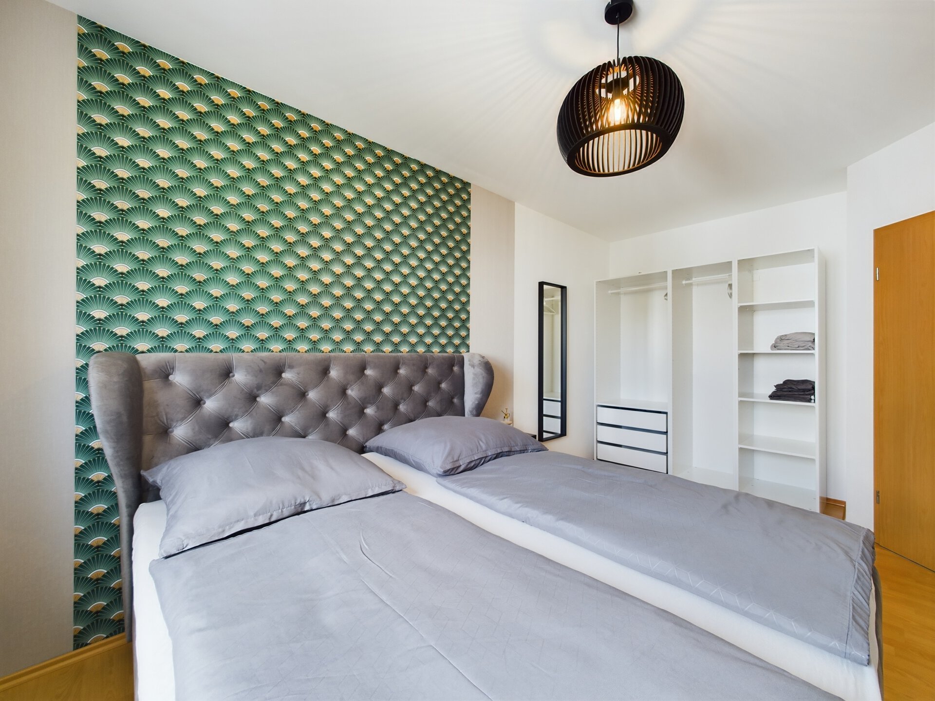 Spacious bedroom with modern decor and a textured accent wall near Ramstein Air Base.