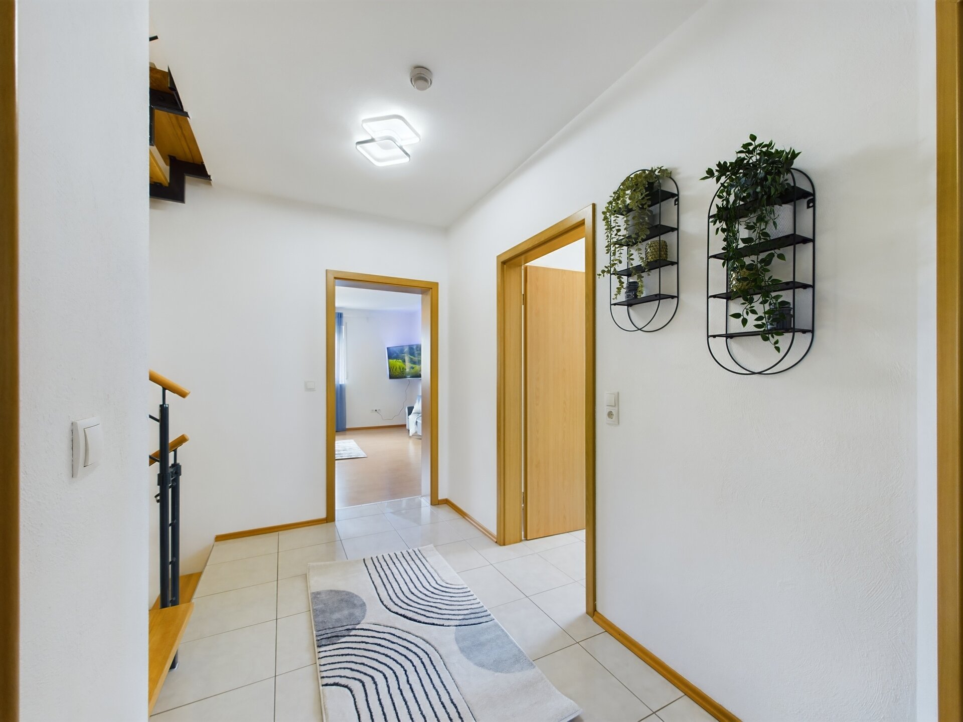 Bright and welcoming hallway with modern decor and potted plants near Ramstein Air Base.