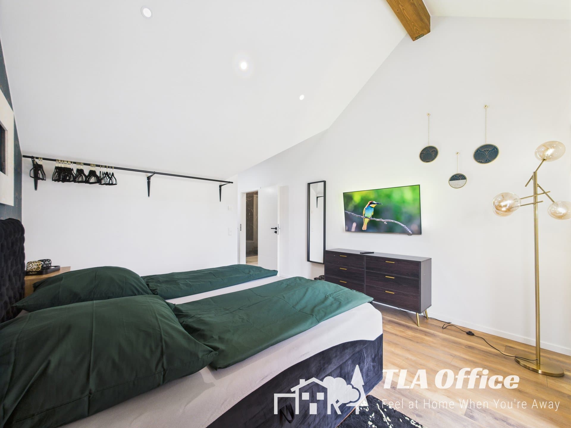 Modern bedroom with green bedding and stylish decor in a spacious apartment near Ramstein Air Base.